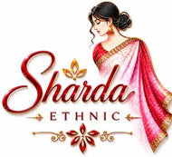 Digital graphic logo featuring the text 'Sharda ETHNIC' in red and gold lettering, accompanied by an illustration of a woman in a pink and red saree with gold borders, set against a plain white background.